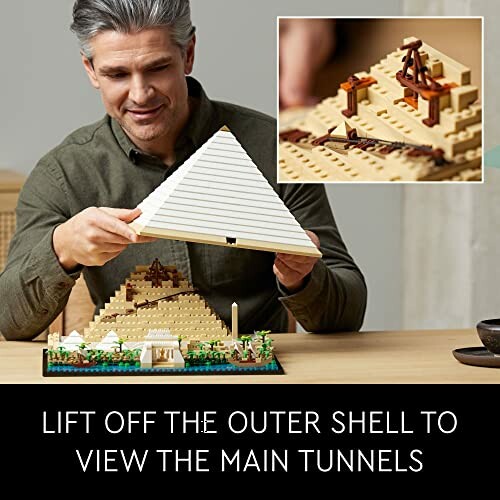 Man lifting Lego pyramid to reveal main tunnels.